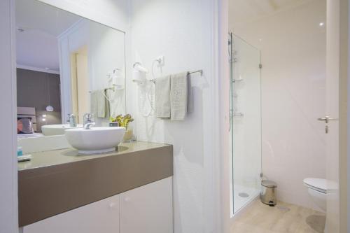 uma casa de banho branca com um lavatório e um WC em Oasis Belorizonte em Santa Maria