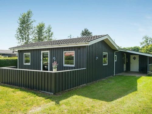 una casa verde con un exterior negro en 6 person holiday home in Haderslev en Diernæs
