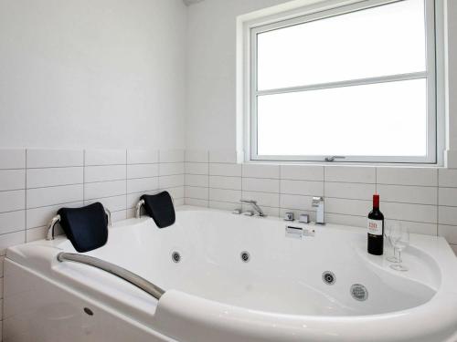 una bañera blanca con una botella de vino. en 10 person holiday home in L kken, en Løkken