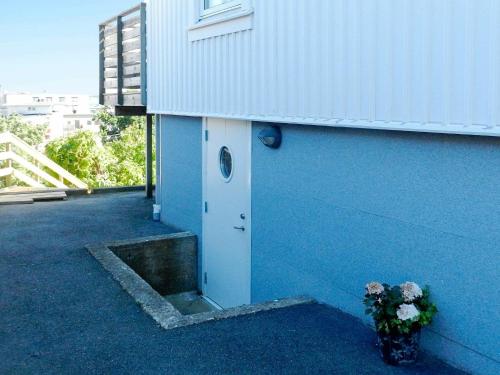 um edifício azul com uma porta e um vaso de flores em 5 person holiday home in LYSEKIL em Lysekil