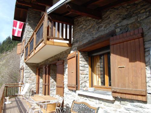 Le VillardにあるMagnificent chalet with saunaの木製のドアとバルコニー付きの石造りの家