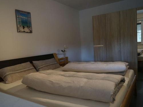 a bedroom with two beds and a cabinet at Urbach 19 in Bad Waldsee