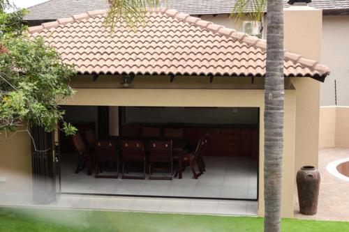 a patio with a group of chairs on a house at Letsatsing Lodge in Rustenburg