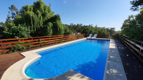 a swimming pool with blue water in a backyard at Brisas del Lago Tandil in Tandil