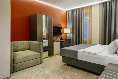 een hotelkamer met een bed en een stoel bij Barin Residence Myasnitskaya in Moskou