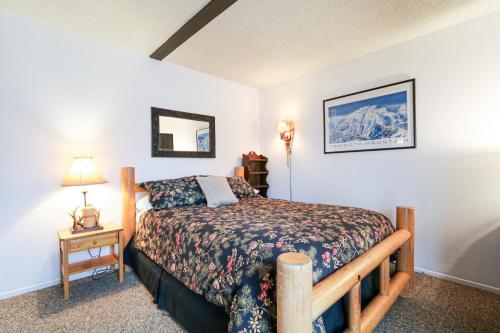 a bedroom with a bed and a table with a lamp at Bigwood #80 condo in Mammoth Lakes