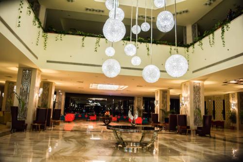 a lobby with chandeliers and a table and chairs at Tolip Taba Resort And Spa in Taba