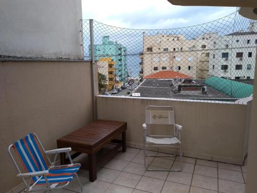 a balcony with a table and chairs and a fence at Meu verao em ITAPEMA in Itapema