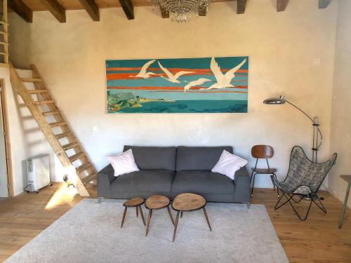 a living room with a couch and two birds at Caseta a masia Les Corominotes in Olot