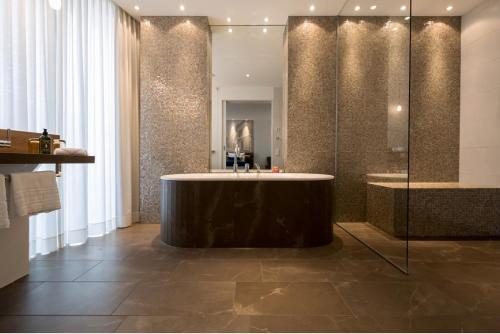 a large bathroom with a tub and a shower at LA MAISON hotel & spa in Saarlouis