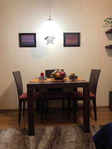 a wooden table with chairs and a bowl of fruit on it at Studio Mišel in Vrnjačka Banja