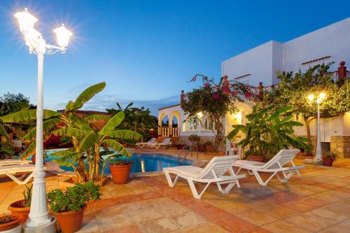 a courtyard with chairs and a swimming pool at night at Can Ramos in Ses Fontanelles