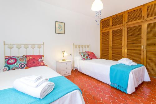 a bedroom with two beds with towels on them at Can Ben Parit in San Antonio