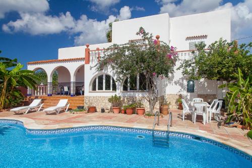 a villa with a swimming pool in front of a house at Can Ramos in Ses Fontanelles