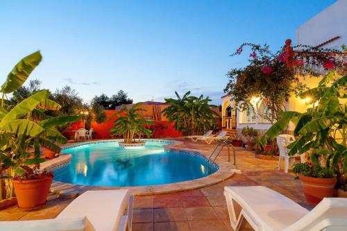 a swimming pool in a patio with chairs and plants at Can Ramos in Ses Fontanelles