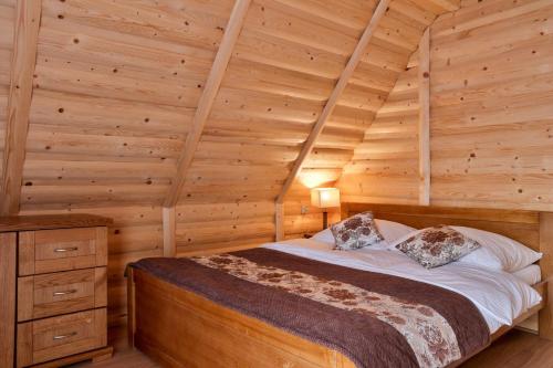 a bedroom with a bed in a log cabin at Leśny Dwór Premium Chalets Zakopane in Murzasichle