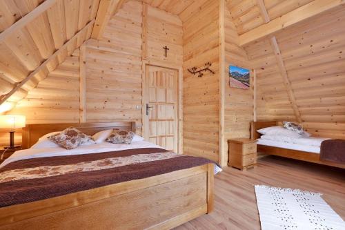 a bedroom with a bed in a log cabin at Leśny Dwór Premium Chalets Zakopane in Murzasichle