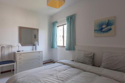 a bedroom with a bed and a dresser and a window at Modern Top Floor Apartment 60m2 - Balcony with Pool & Sea View - Vilamoura in Vilamoura