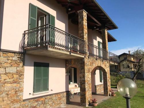 a house with a balcony on the side of it at Villa The Princess in Lenno