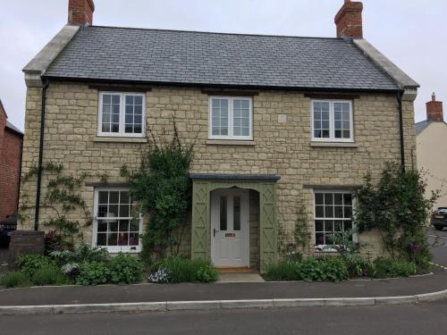 a brick house with a white door at 34 Grosvenor Drive in Tisbury