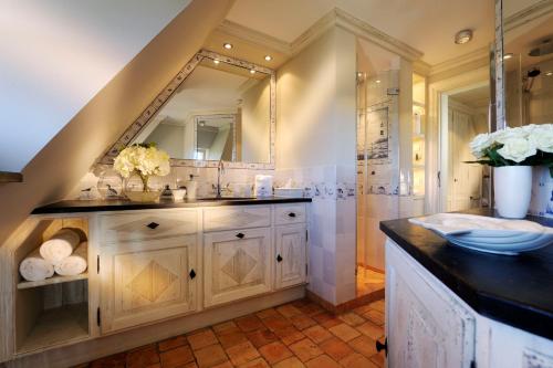 a bathroom with a sink and a mirror at SalzWasserHerz Senhoog Luxury Holiday Homes ***** in Morsum