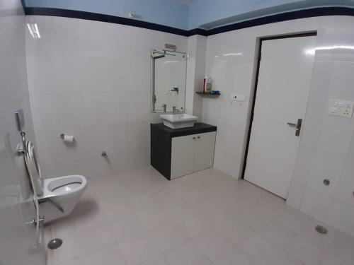 a bathroom with a toilet and a sink and a shower at Swiss House in Jodhpur