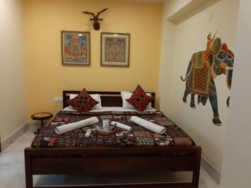 a bedroom with a bed with a cow on the wall at Swiss House in Jodhpur