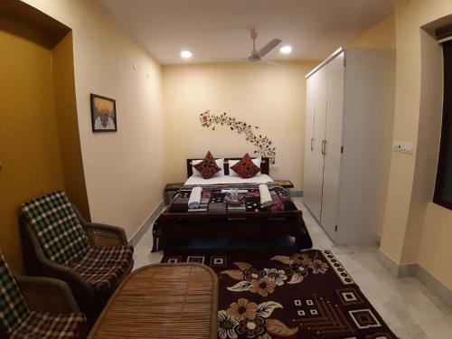 a bedroom with a bed and two chairs at Swiss House in Jodhpur
