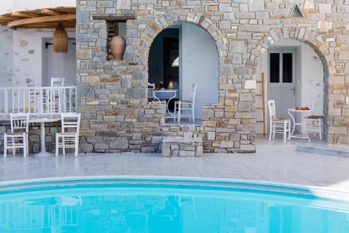 a stone house with a swimming pool and a patio at Zefi Hotel & Suites in Naousa