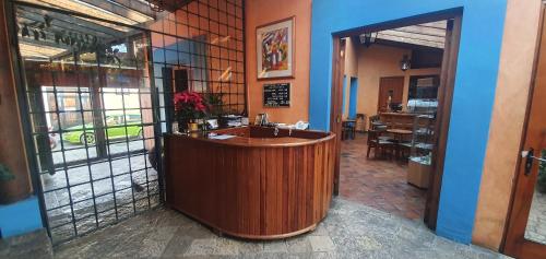 a restaurant with a bar in the middle of a room at Hotel Posada El Paraíso in San Cristóbal de Las Casas
