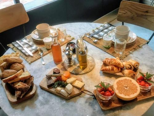 a table topped with different types of bread and pastries at Le 19-21 - Un amour d'hotel in Leucate