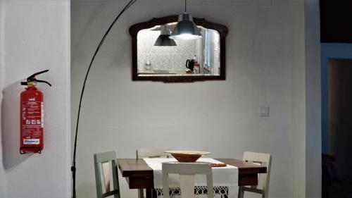 a dining room with a table and a fire extinguisher at 17 da Rua da Estação in São Pedro do Corval