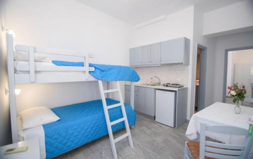a small room with a bunk bed and a kitchen at Studios Akrogiali in Aegiali