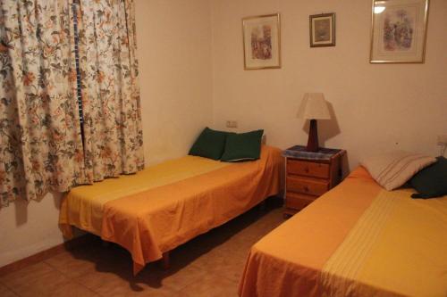 ein Schlafzimmer mit 2 Betten und einer Lampe auf einem Tisch in der Unterkunft 152 Tropicana Park - Deniasol in Denia