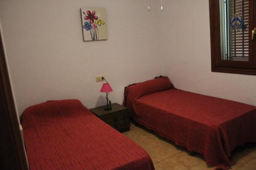 - une chambre avec deux lits et une lampe sur une table dans l'établissement 150 Tropicana Park - Deniasol, à Dénia