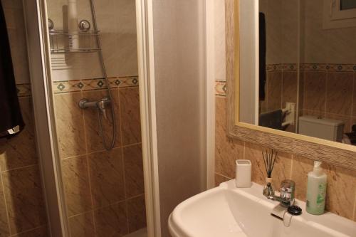 een badkamer met een wastafel en een douche met een spiegel bij 183 Deveses Park - Deniasol in Denia