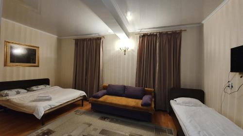 um quarto de hotel com duas camas e um sofá em Fiveseasons em Almaty
