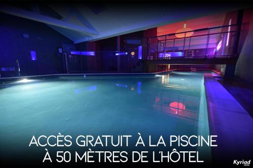 a large swimming pool in a house with a quote at Kyriad Prestige Dijon Centre in Dijon