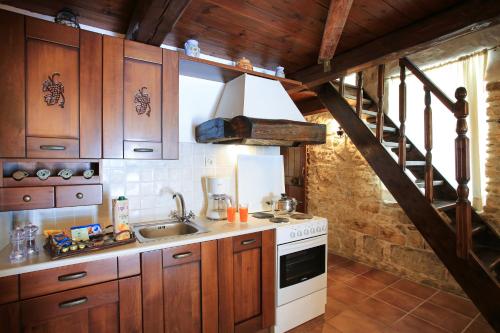 a kitchen with wooden cabinets and a sink and a staircase at Villa Radamanthis in Sívas