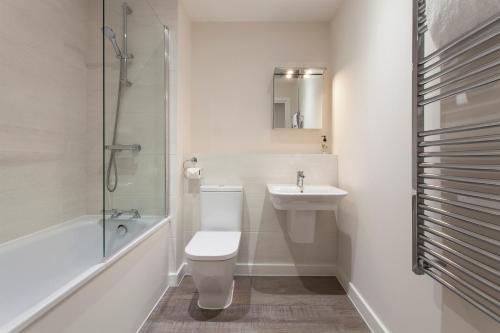 a bathroom with a toilet and a sink and a shower at Southampton City Apartments by Charles Hope in Southampton