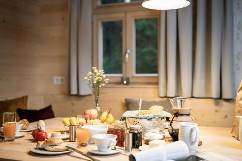 a table with breakfast foods and drinks on it at Ramenai - Das Böhmerwaldlerdorf in Ulrichsberg