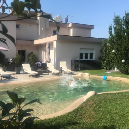 a person swimming in a pool in a backyard at Apartments Bego Spa & Wellness in Crikvenica