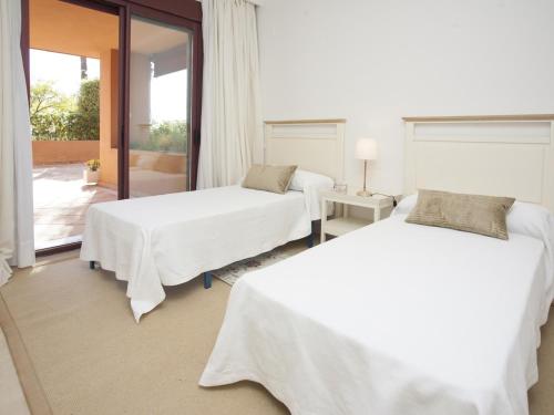 2 Betten in einem weißen Zimmer mit Fenster in der Unterkunft GRAN BAHIA de Marbella in Marbella