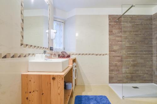 un baño con lavabo y ducha en Cesa San Florian - Appartamento 1, en Canazei