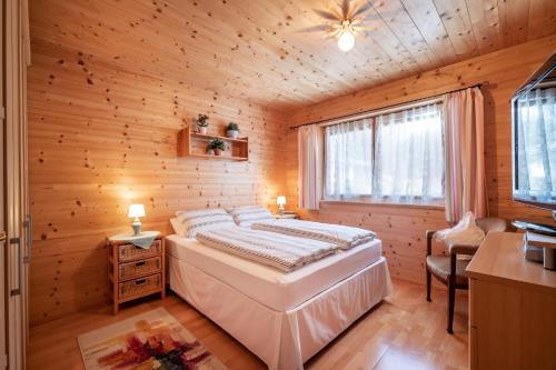 een slaapkamer met een bed in een houten kamer bij Chalet Terry in Sankt Johann in Tirol