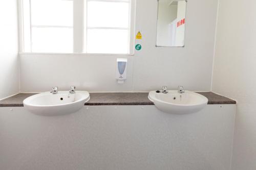 a bathroom with two white sinks and a window at Durness Youth Hostel in Durness