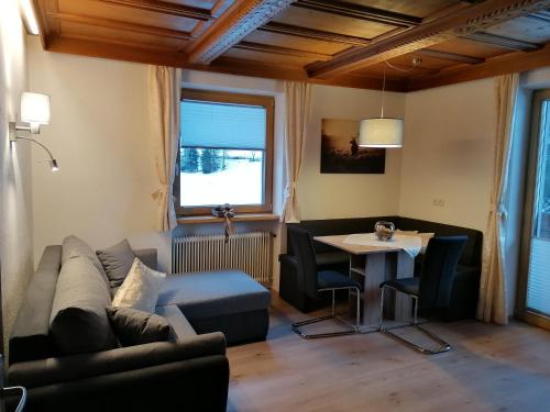 ein Wohnzimmer mit einem Sofa und einem Tisch in der Unterkunft Mooshof in Kaunertal