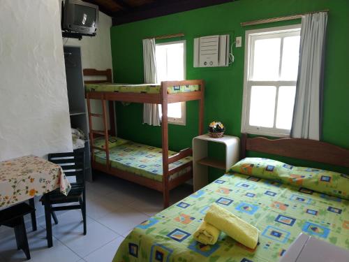 een slaapkamer met 2 stapelbedden en groene muren bij Residencial Casabella in Florianópolis