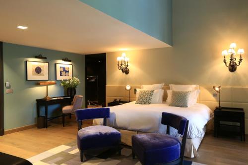 a bedroom with a bed and two chairs and a desk at Domaine De Manville in Les Baux-de-Provence