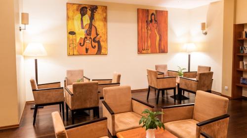 a dining room with tables and chairs and paintings on the wall at Qubus Hotel Głogów in Głogów